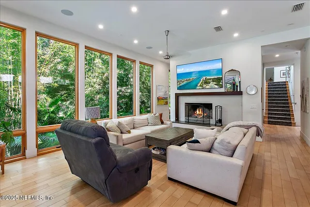 a living room with furniture a fireplace and a large window