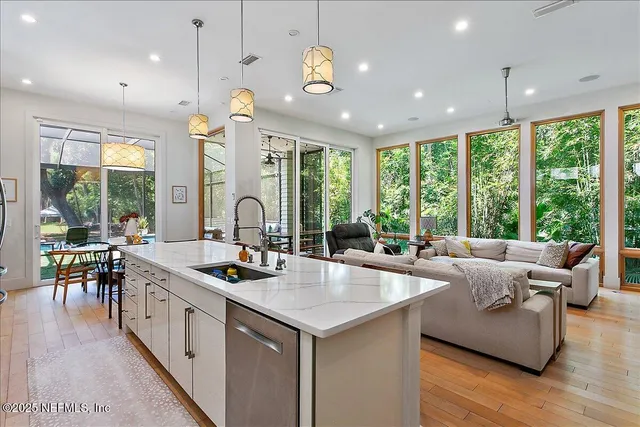 a open kitchen with stainless steel appliances granite countertop a stove and a view of living room