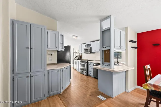 a kitchen with stainless steel appliances a stove microwave and sink