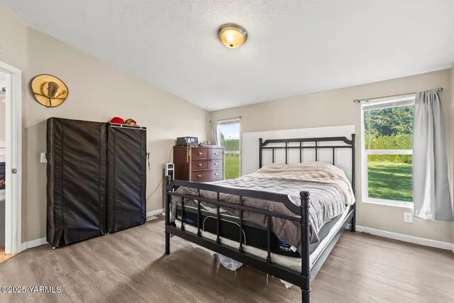 a bedroom with a bed and a painting on the wall