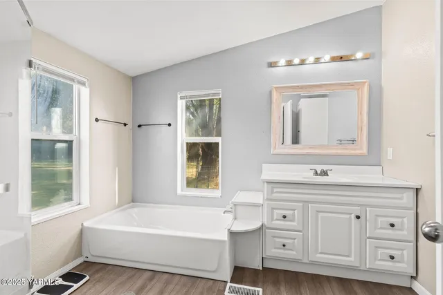 a bathroom with a toilet a sink a tub and mirror