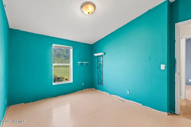 a view of a bedroom with a large bed and wooden floor