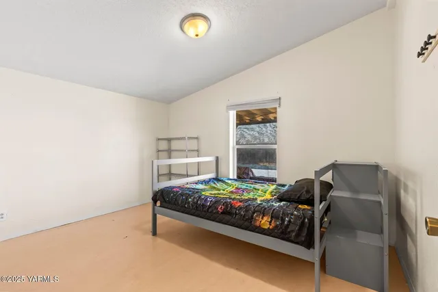 a view of a room with gym equipment and wooden floor