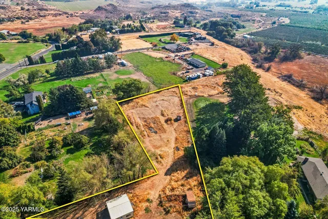 an aerial view of a tennis ground and a cars park side of the road