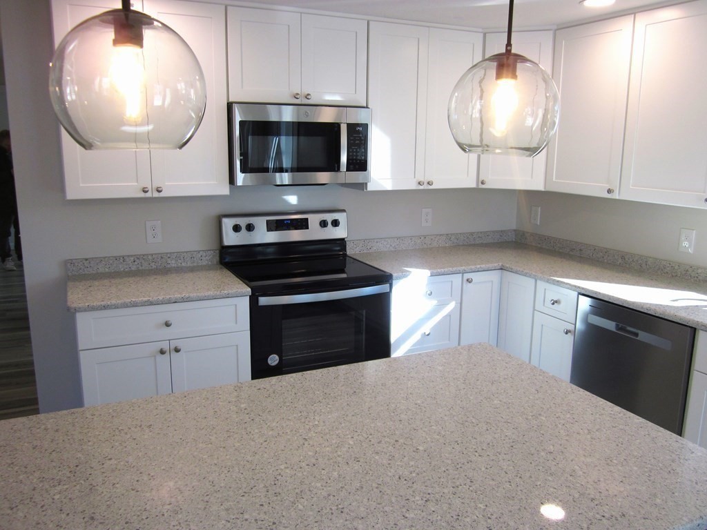 6 James Street Webster, MA 01570 - Photo 13 of 37 a kitchen with cabinets stainless steel appliances and a chandelier