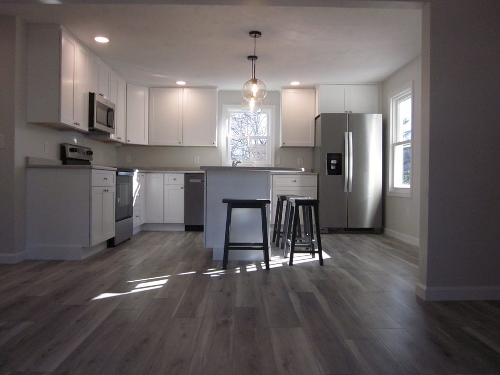 6 James Street Webster, MA 01570 - Photo 17 of 37 a view of a kitchen with granite countertop stainless steel appliances refrigerator wooden floor dining table and chairs