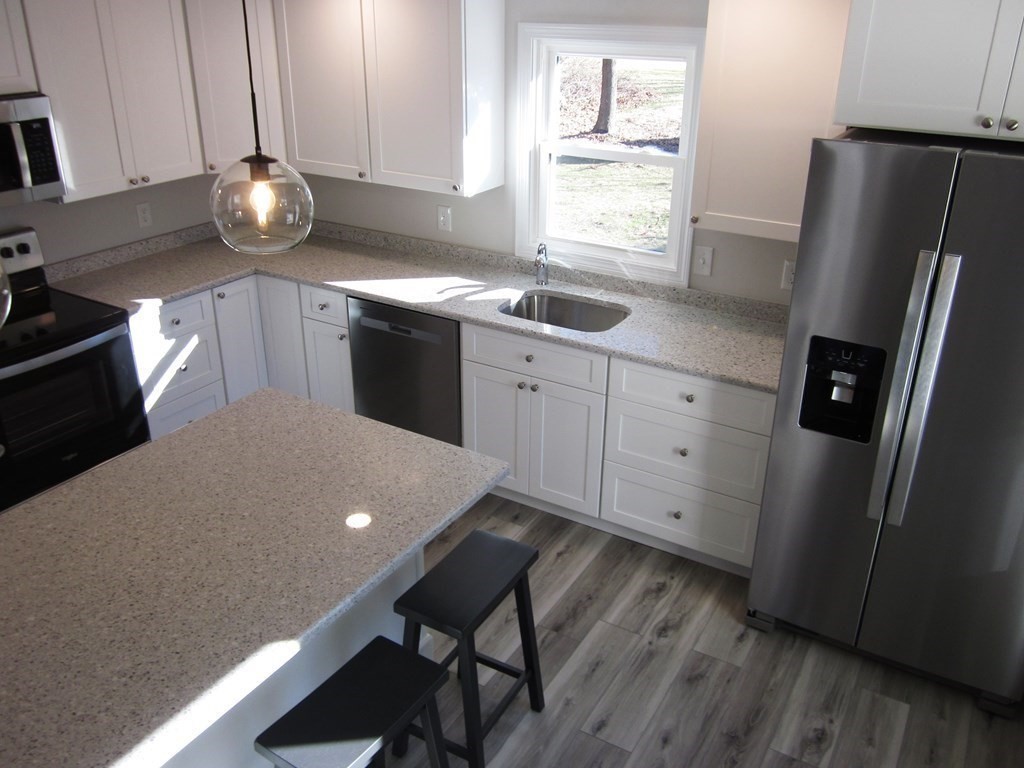 6 James Street Webster, MA 01570 - Photo 7 of 37 a kitchen with stainless steel appliances a refrigerator sink and wooden floor