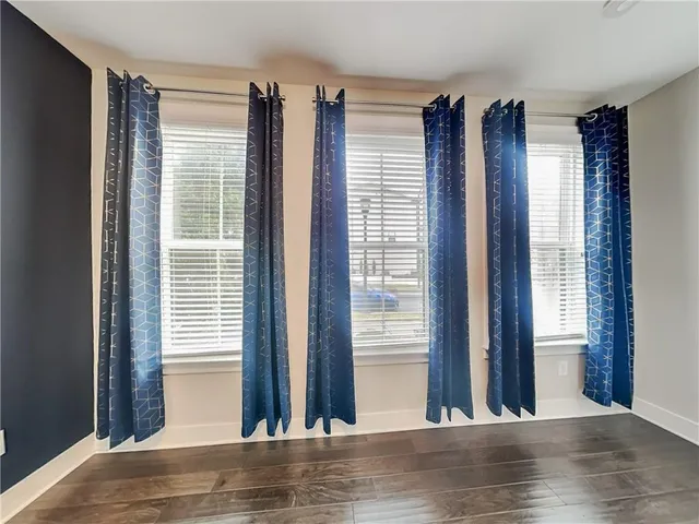 a view of a room with a large window and wooden floor