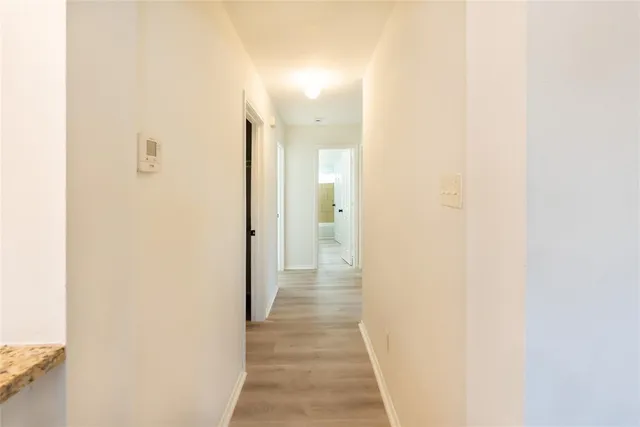 a view of a hallway with wooden floor
