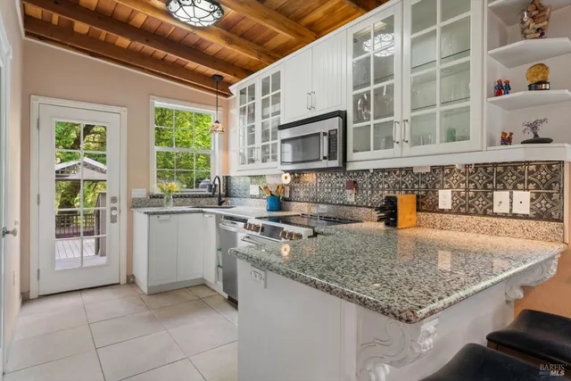 a kitchen with stainless steel appliances granite countertop a sink dishwasher stove and a microwave oven with cabinets