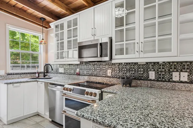 a kitchen with stainless steel appliances granite countertop a sink and a stove