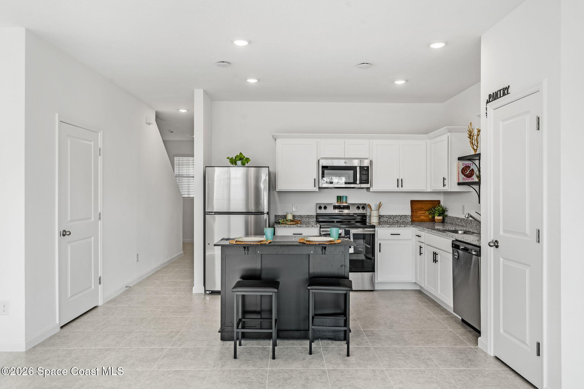 2117 Topsail Way Rockledge, FL 32955 - Photo 4 of 16 a kitchen with kitchen island wooden cabinets and refrigerator