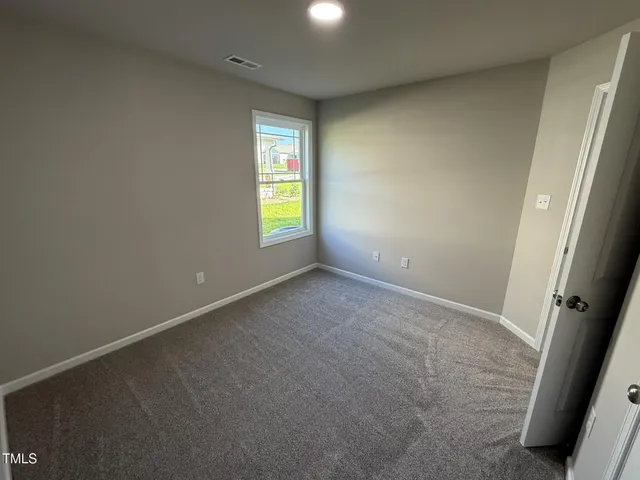 an empty room with a window and a fireplace