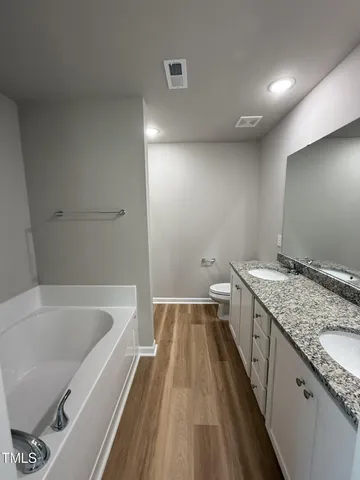 a bathroom with a granite countertop sink and a bathtub