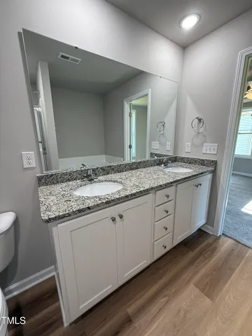 a bathroom with a granite countertop sink and a mirror