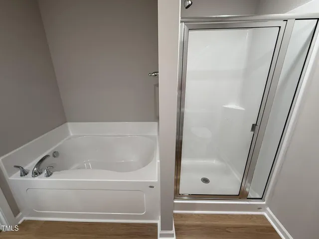 a white bath tub sitting next to a shower