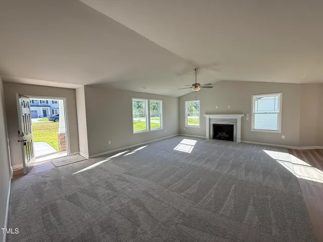 a view of empty room with a fireplace and window