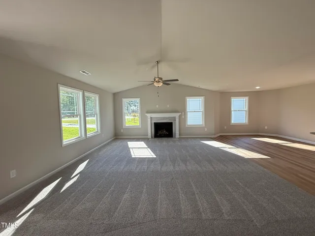 an empty room with windows and fireplace