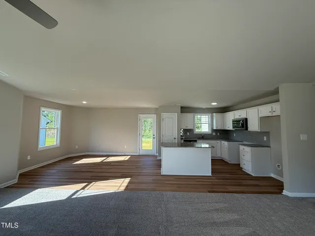 a kitchen with stainless steel appliances kitchen island granite countertop a refrigerator sink and white cabinets
