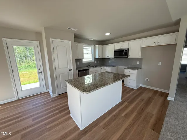 a kitchen with granite countertop a sink and a stove top oven