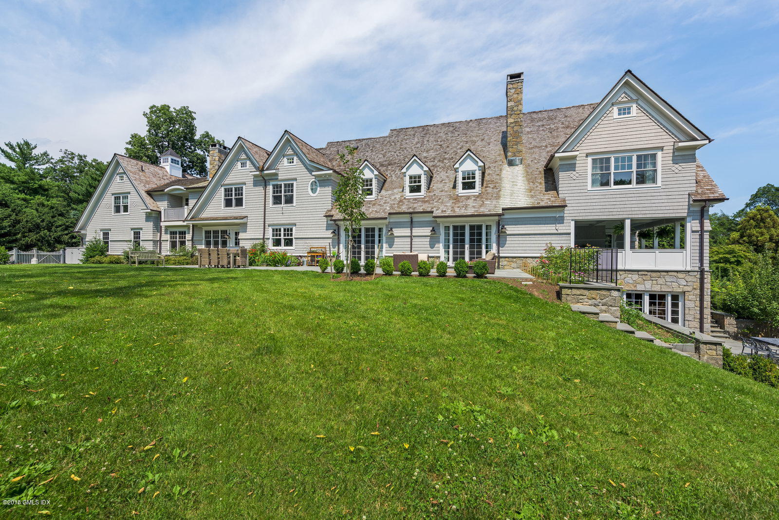 136 Parsonage Road Greenwich, CT 06830 - Photo 22 of 35 a front view of a house with a garden and trees