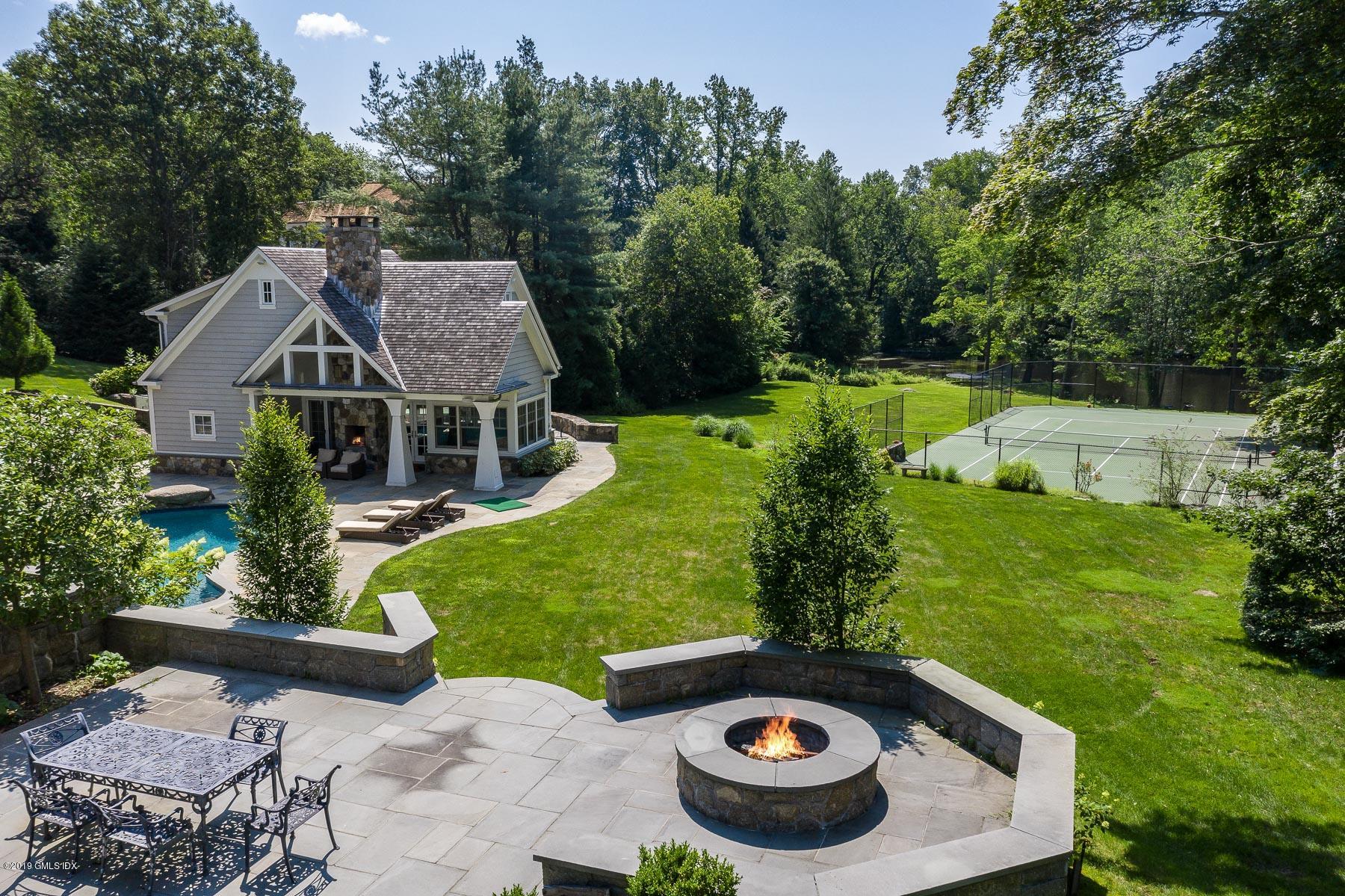 136 Parsonage Road Greenwich, CT 06830 - Photo 26 of 35 a view of a backyard with table and chairs plants and large trees
