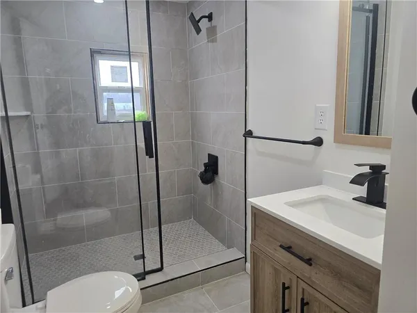 a bathroom with a sink a toilet and shower