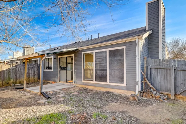 a backyard of a house with barbeque oven and wooden fence