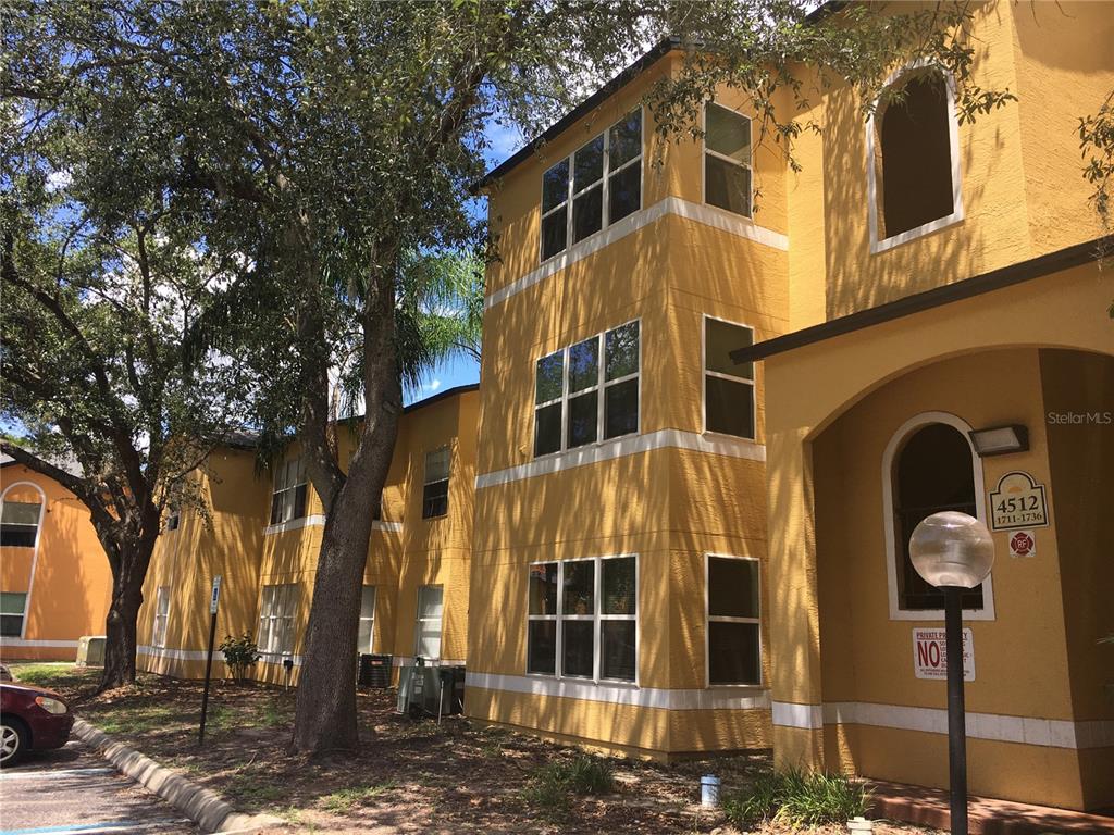 a front view of a building with a tree