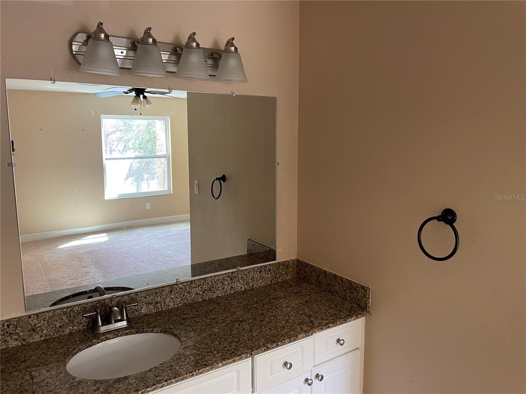 4512 Commander Drive, Unit 1725 Orlando, FL 32822 - Photo 17 of 17 a bathroom with a granite countertop sink and a mirror