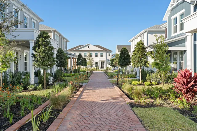 a view of a brick house with a yard and plants