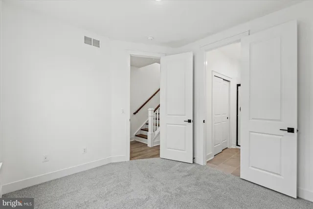 an empty room with staircase and white walls