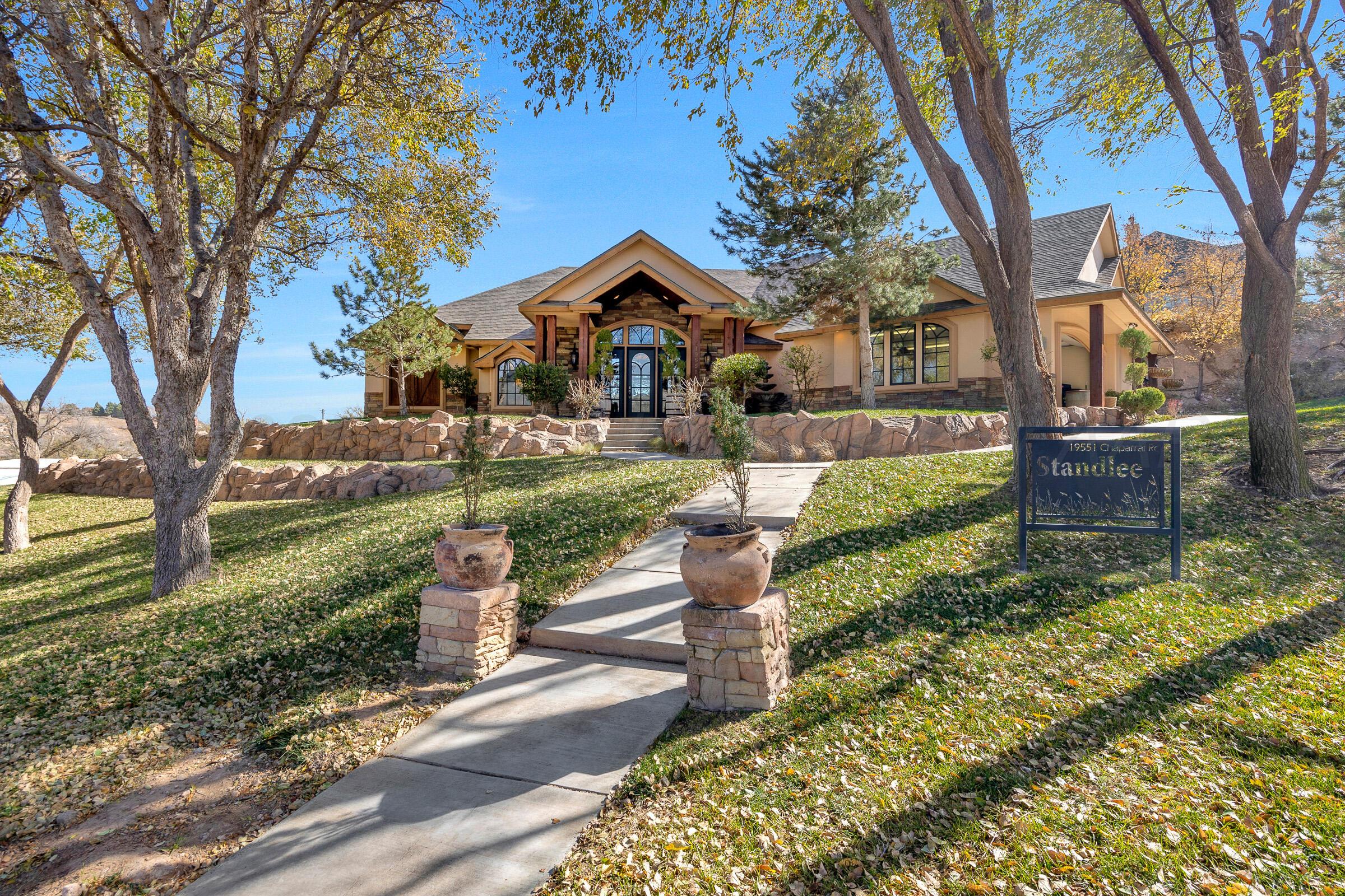 a front view of a house with a yard and fountain