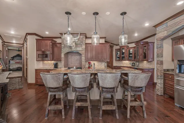 a dining table with chairs and kitchen view