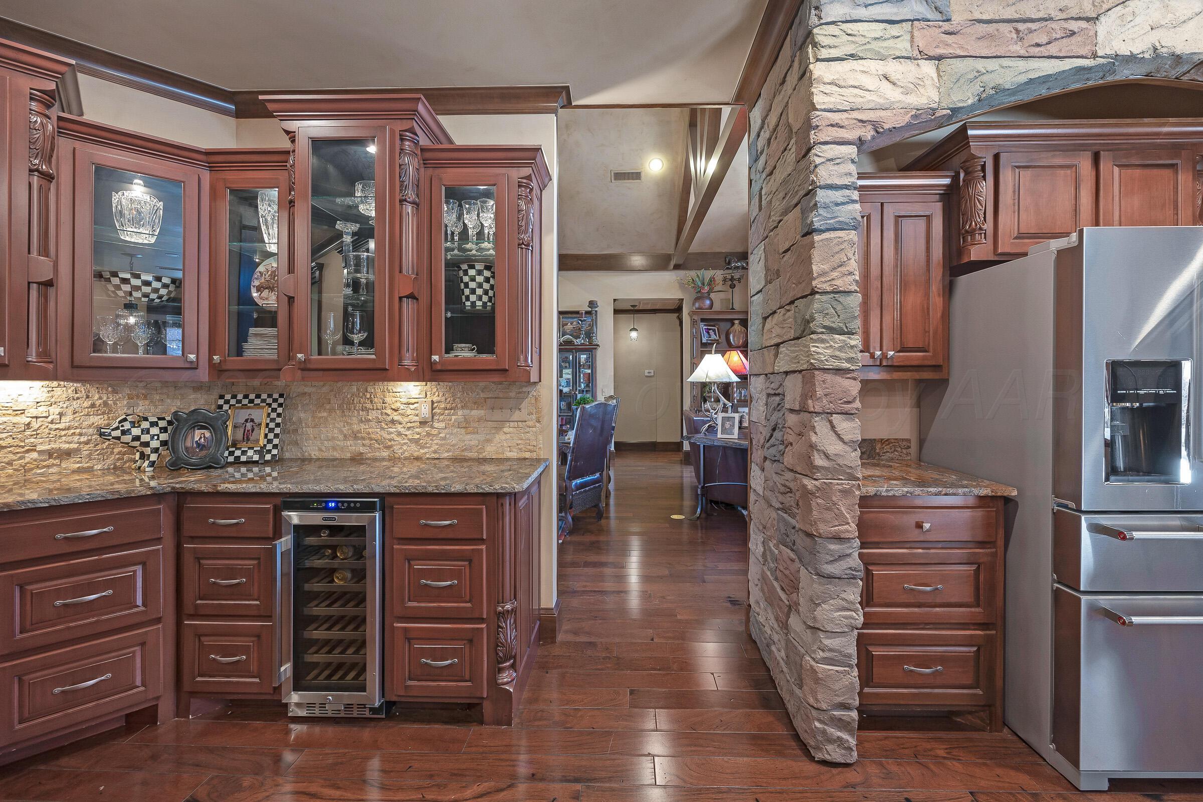 19551 Chaparral Road Canyon, TX 79015 - Photo 15 of 42 a kitchen with a wooden floor and a refrigerator
