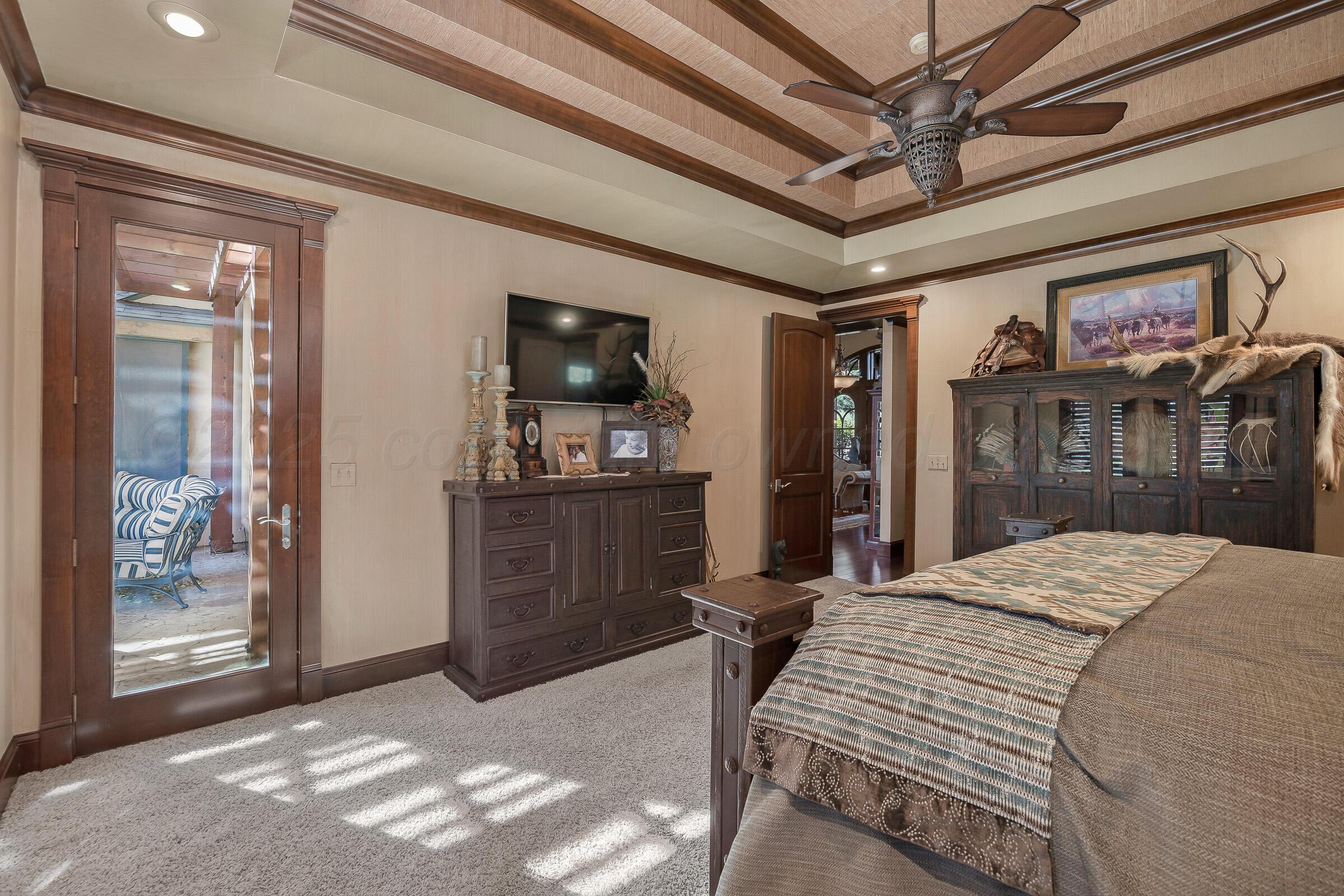 19551 Chaparral Road Canyon, TX 79015 - Photo 19 of 42 a bedroom with a bed dresser and a flat tv screen