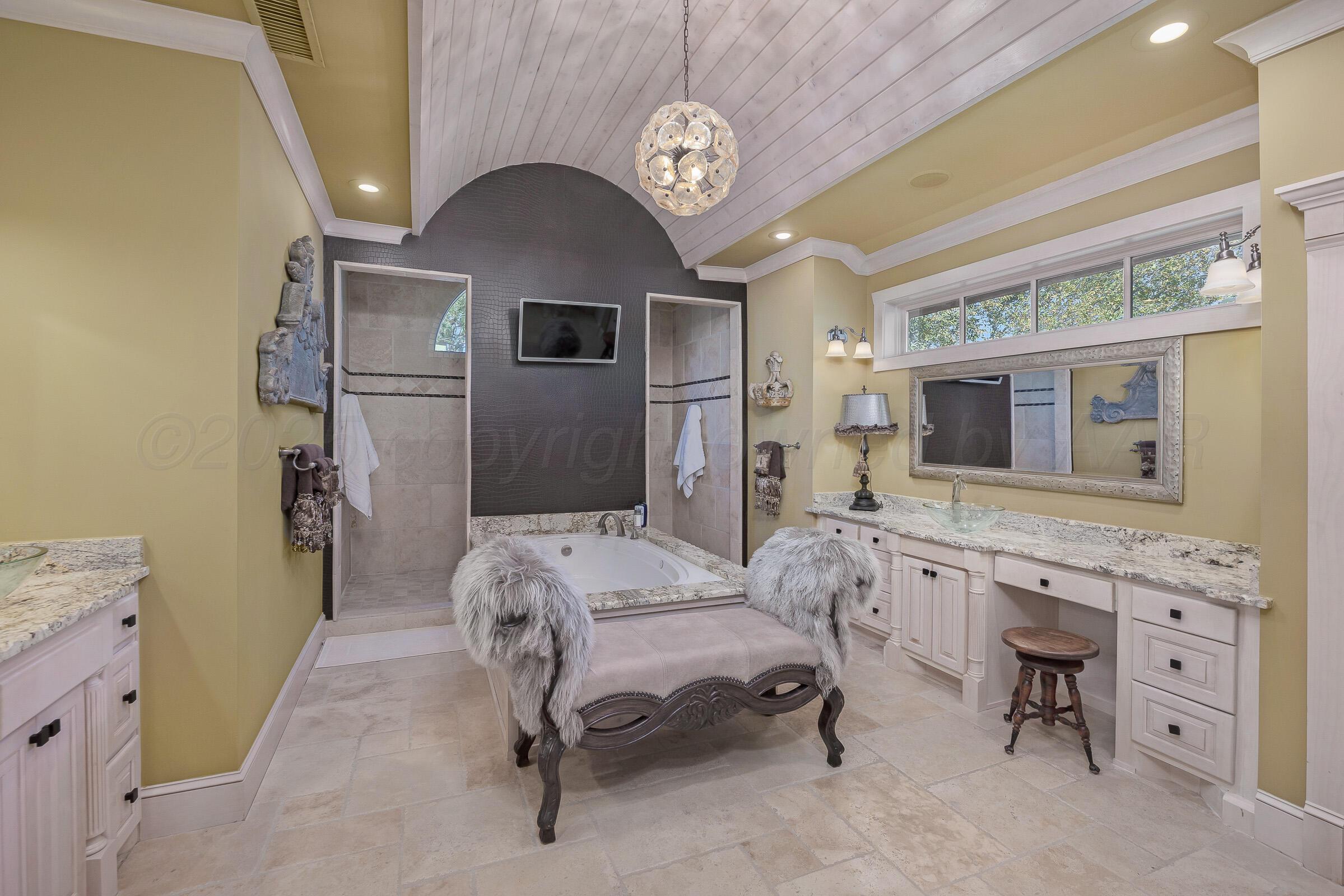 19551 Chaparral Road Canyon, TX 79015 - Photo 20 of 42 a spacious bedroom with a bed and a chandelier