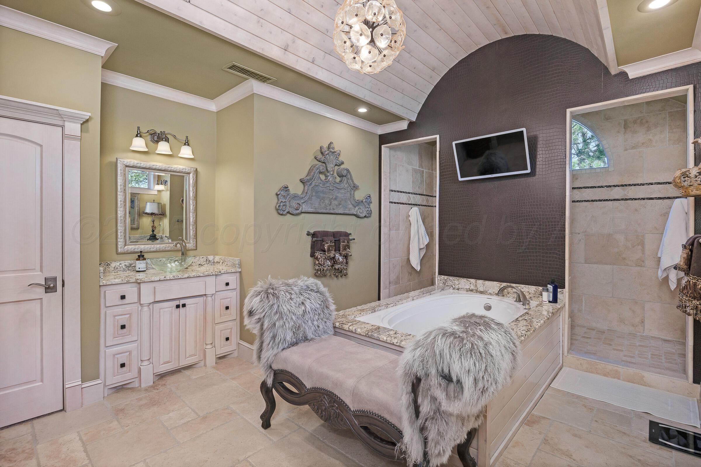 19551 Chaparral Road Canyon, TX 79015 - Photo 21 of 42 a bedroom with a bed and a chandelier