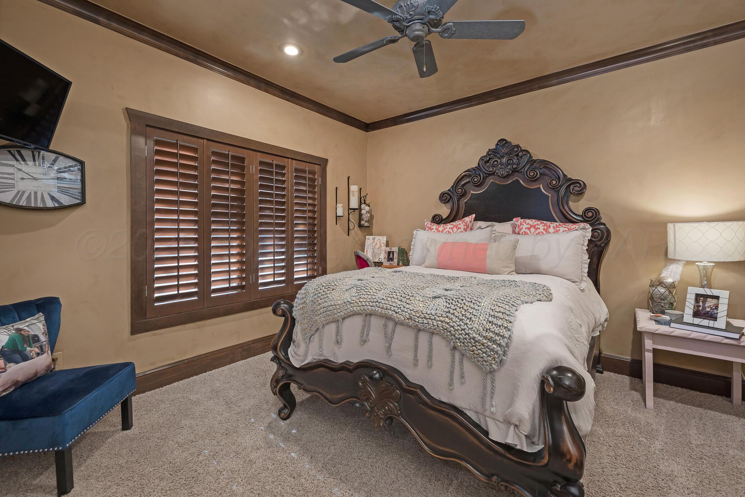 19551 Chaparral Road Canyon, TX 79015 - Photo 25 of 42 a bedroom with a bed and a chandelier