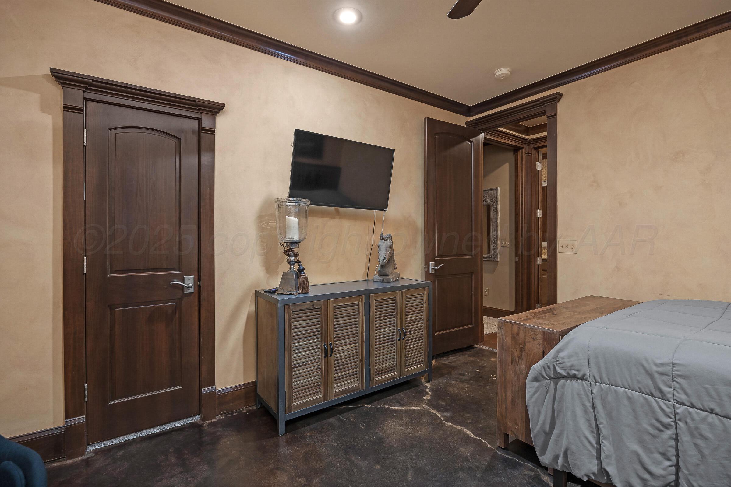 19551 Chaparral Road Canyon, TX 79015 - Photo 30 of 42 a bedroom with a bed and a flat tv screen on dresser