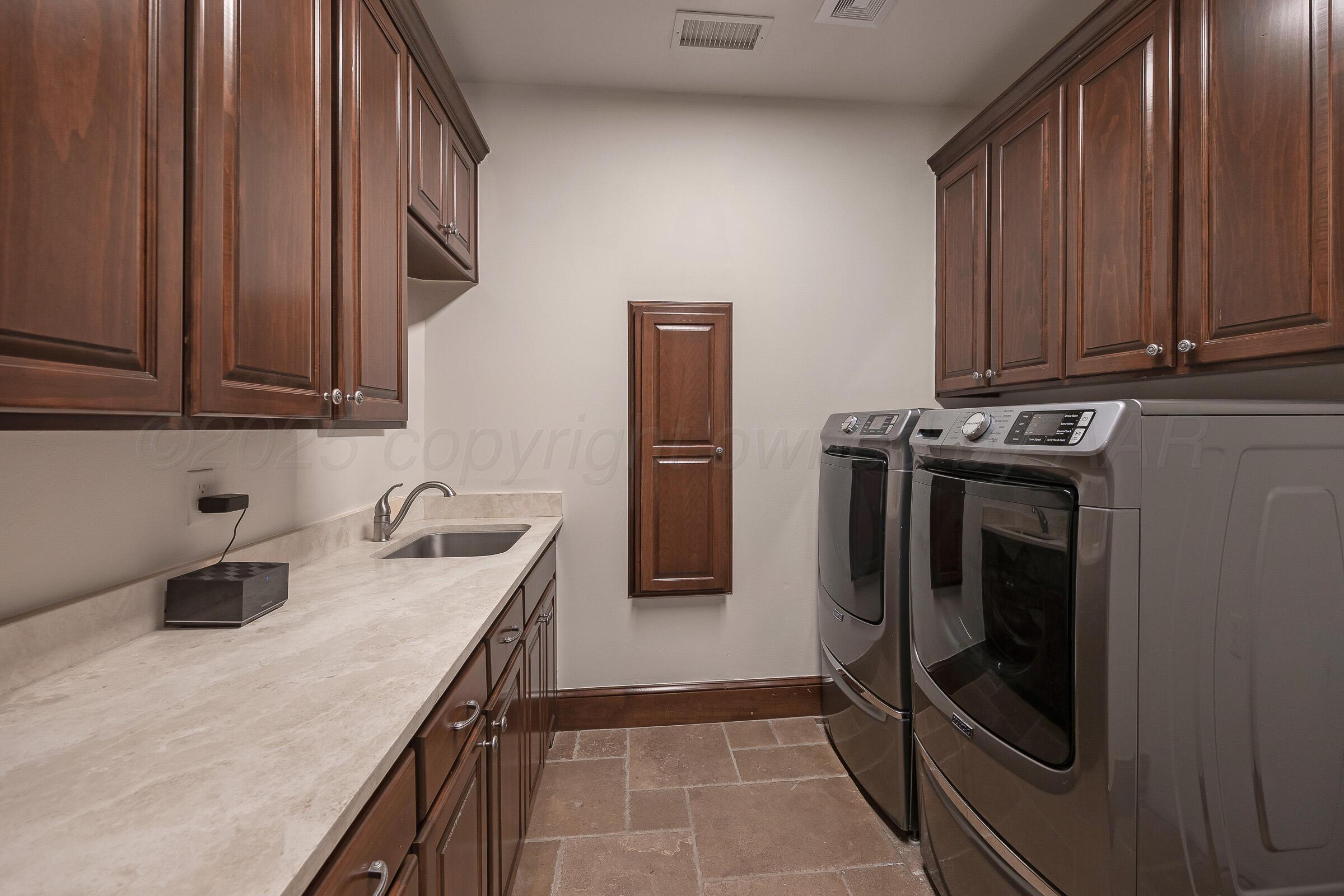 19551 Chaparral Road Canyon, TX 79015 - Photo 31 of 42 a kitchen with stainless steel appliances granite countertop a refrigerator a stove and a sink with wooden cabinets