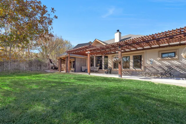 a view of a house with a big yard and large trees