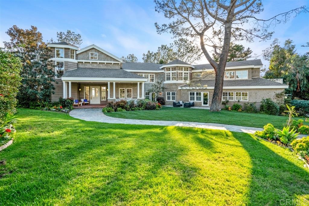 a front view of a house with a yard patio and green space