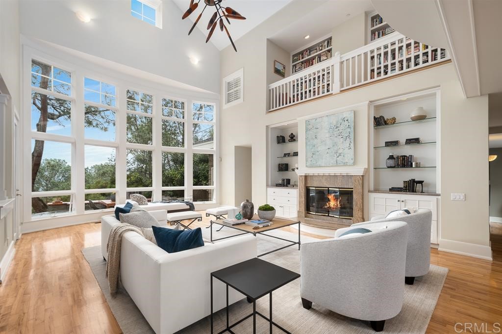 13598 Nogales Drive Del Mar, CA 92014 - Photo 4 of 21 a living room with furniture a fireplace and a dining table with wooden floor