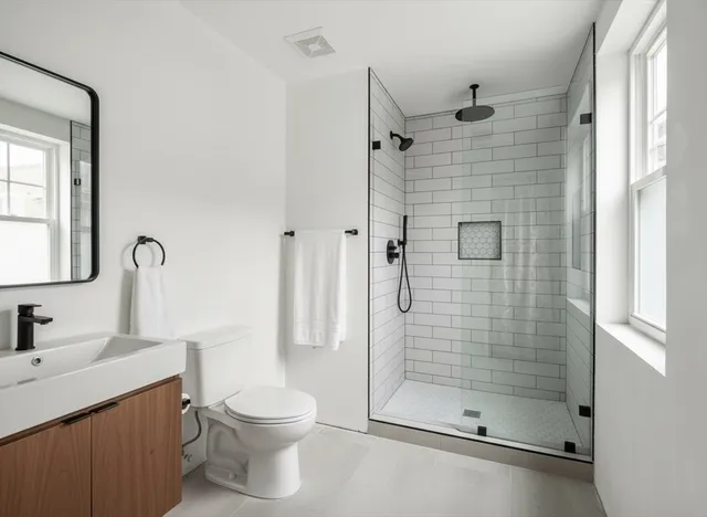 a bathroom with a shower a toilet and a sink