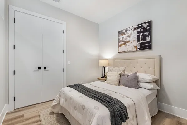 a bedroom with a bed and a painting on the wall