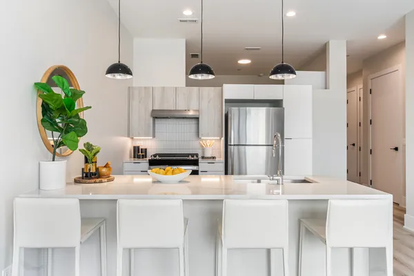 a kitchen with stainless steel appliances kitchen island granite countertop a refrigerator a sink and a stove