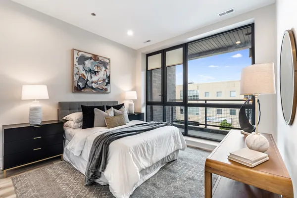 a spacious bedroom with a bed and a large window