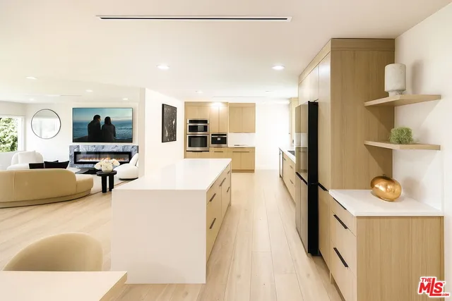 a large living room with stainless steel appliances kitchen island granite countertop furniture and a kitchen view