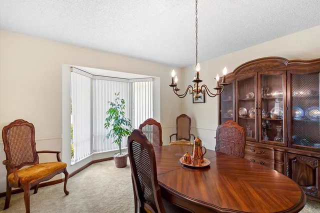 a dining room with furniture a chandelier and window